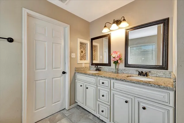 a bathroom with a double vanity sink and a mirror