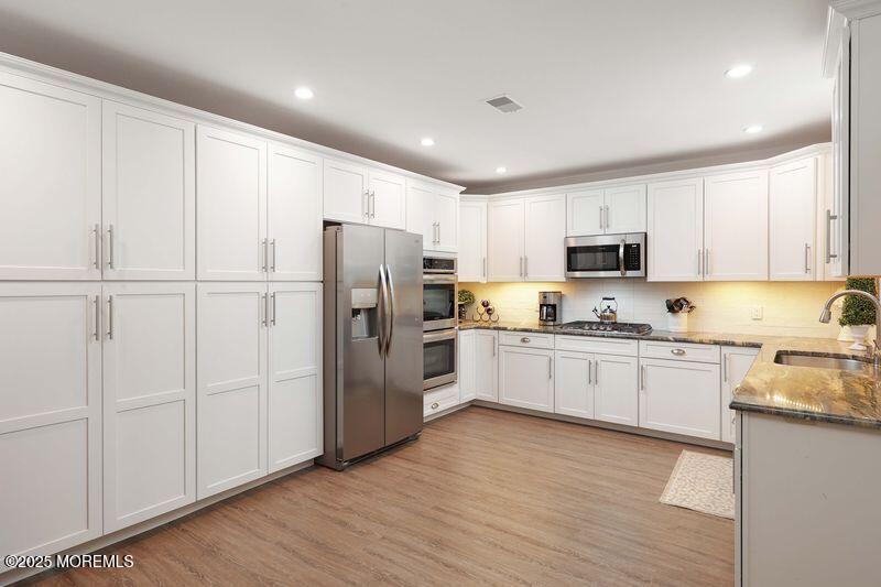 63 Carpenter Street Red Bank, NJ 07701 - Photo 12 of 35 a kitchen with granite countertop white cabinets and refrigerator