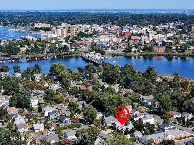 an aerial view of a houses with a yard and lake view