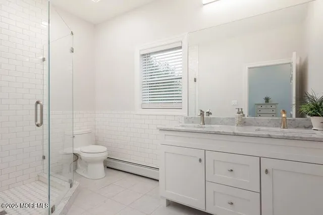 a bathroom with a granite countertop toilet sink and mirror