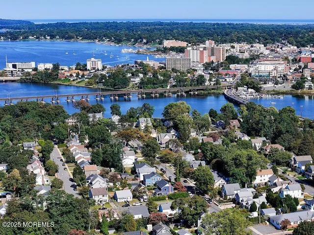 an aerial view of a city with lots of residential buildings and mountain view in back