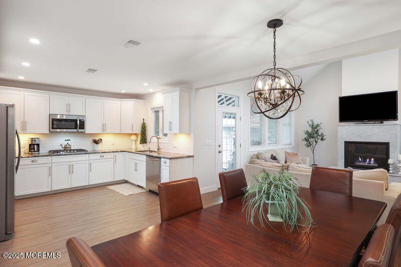 63 Carpenter Street Red Bank, NJ 07701 - Photo 7 of 35 a kitchen with stainless steel appliances granite countertop a stove top oven a sink dishwasher a dining table and chairs with wooden floor