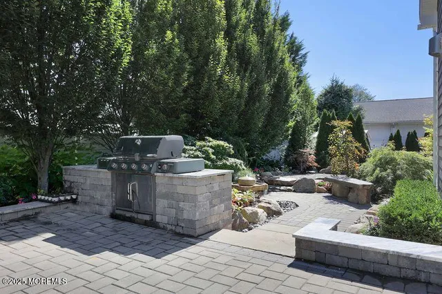 a view of a patio with table and chairs potted plants and large tree
