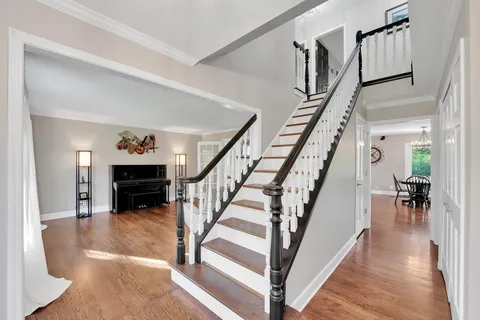 a view of entryway and hall with wooden floor