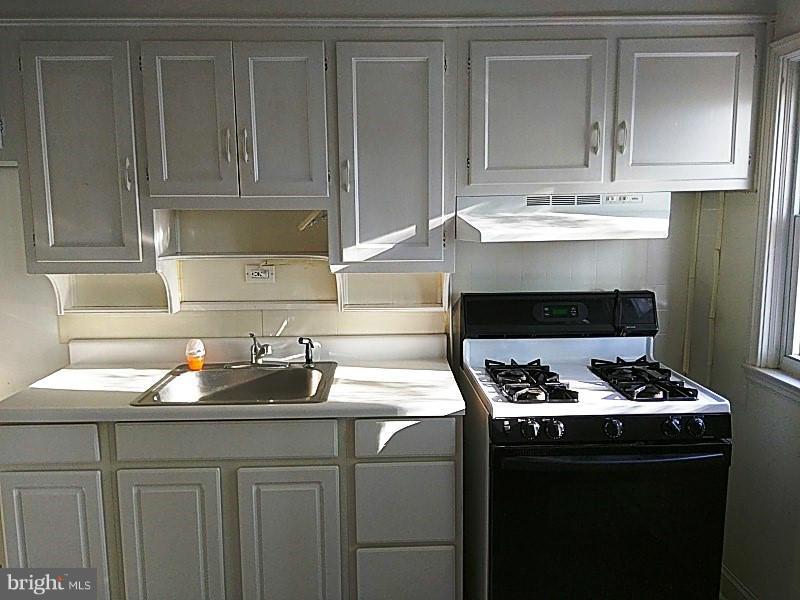 842 Braeside Road Baltimore, MD 21229 - Photo 15 of 26 a kitchen with granite countertop a sink stove and cabinets