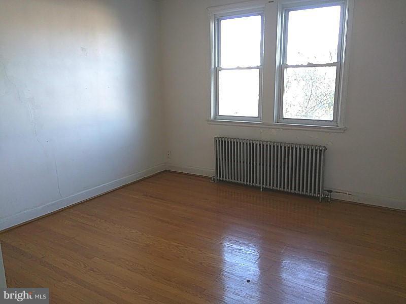 842 Braeside Road Baltimore, MD 21229 - Photo 19 of 26 an empty room with wooden floor and windows