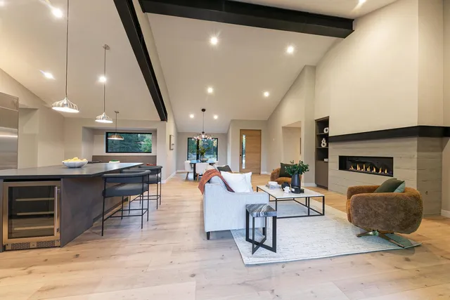 a living room with furniture a rug and kitchen view