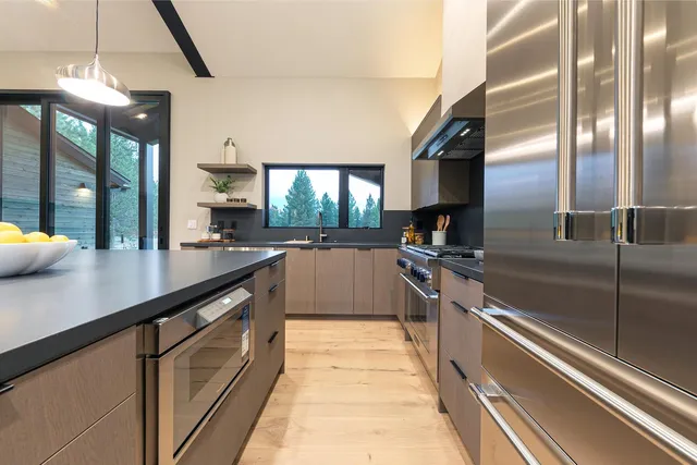 a kitchen with stainless steel appliances granite countertop a sink and a refrigerator