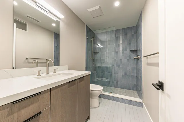 a bathroom with a sink a toilet and shower