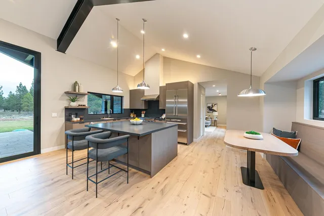 a room with stainless steel appliances kitchen island a table and chairs in it