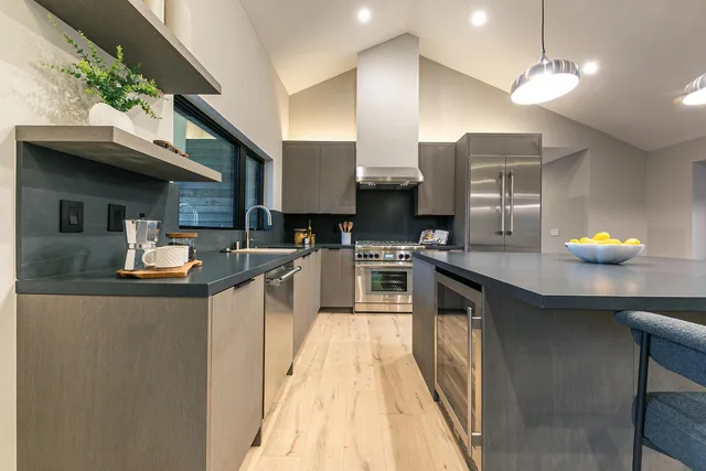 a kitchen with stainless steel appliances granite countertop a sink a stove and a refrigerator