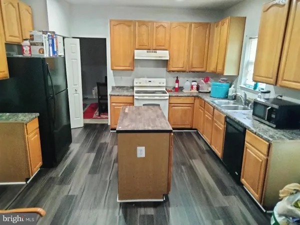 a kitchen with stainless steel appliances a refrigerator sink and wooden floor