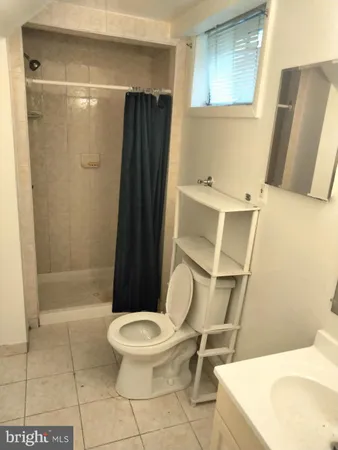 a white toilet sitting next to a bathroom sink and a shower