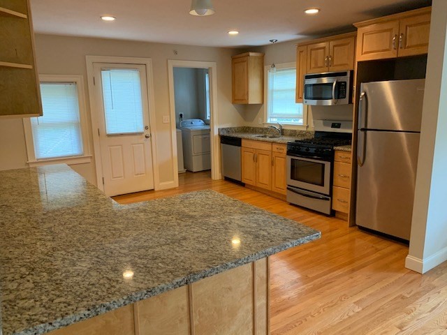54 Desoto Road, Unit 3 Boston, MA 02132 - Photo 1 of 5 a kitchen with stainless steel appliances granite countertop a refrigerator and a stove top oven