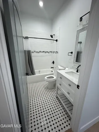a bathroom with a sink a toilet a shower a and mirror