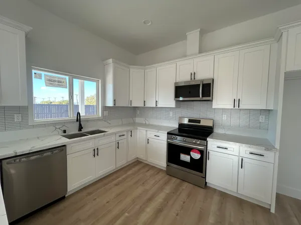 a kitchen with sink a microwave and cabinets