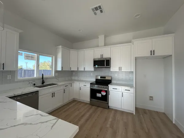 a kitchen with stainless steel appliances granite countertop a sink stove and refrigerator