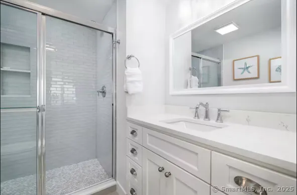 a bathroom with a shower sink and mirror