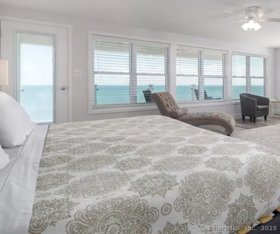 a bedroom with a bed large window with couch and large window