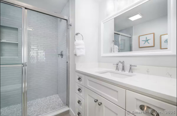 1019 Fairfield Beach Road Fairfield, CT 06824 - Photo 7 of 19 a bathroom with a shower sink and mirror