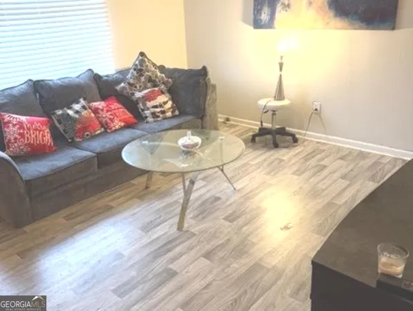 a living room with furniture and wooden floor