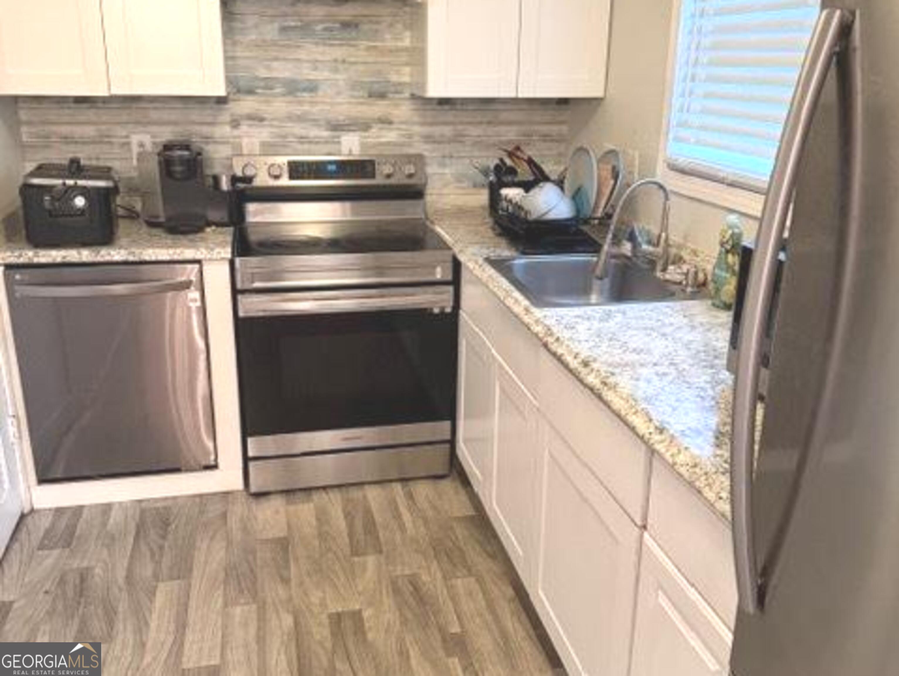 501 Carlton Road, Unit 3B Palmetto, GA 30268 - Photo 10 of 25 a kitchen with granite countertop a stove sink and cabinets