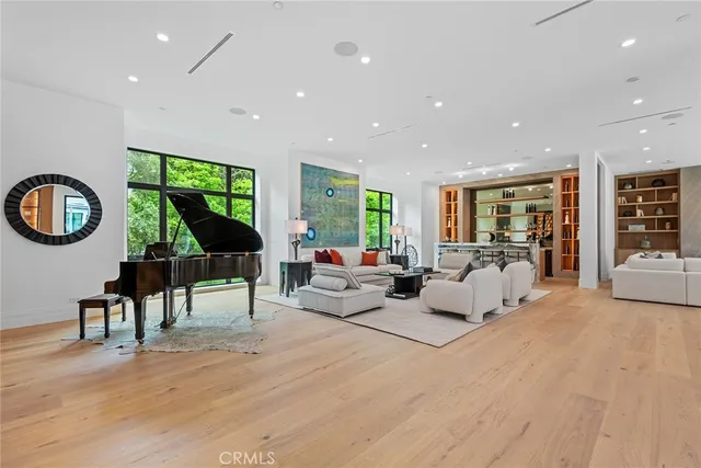 a living room with furniture a rug potted plant and a large window