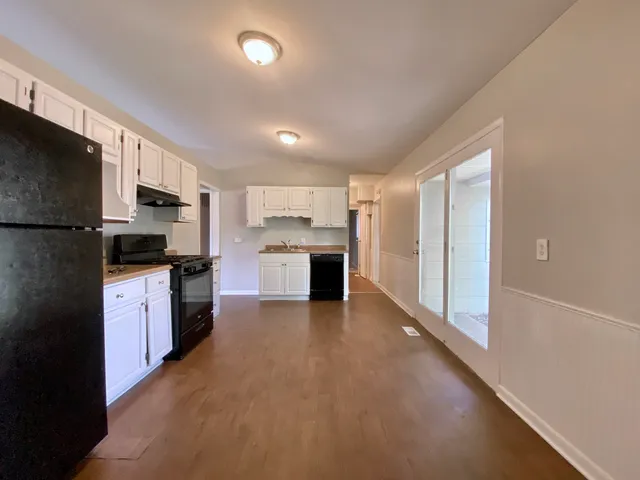 a large kitchen with a refrigerator and a stove top oven