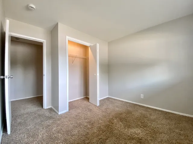 an empty room with closet and a bathroom