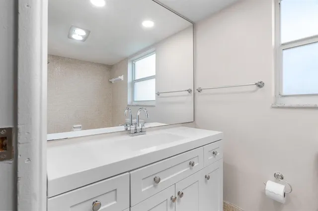 an empty room with windows and cabinet