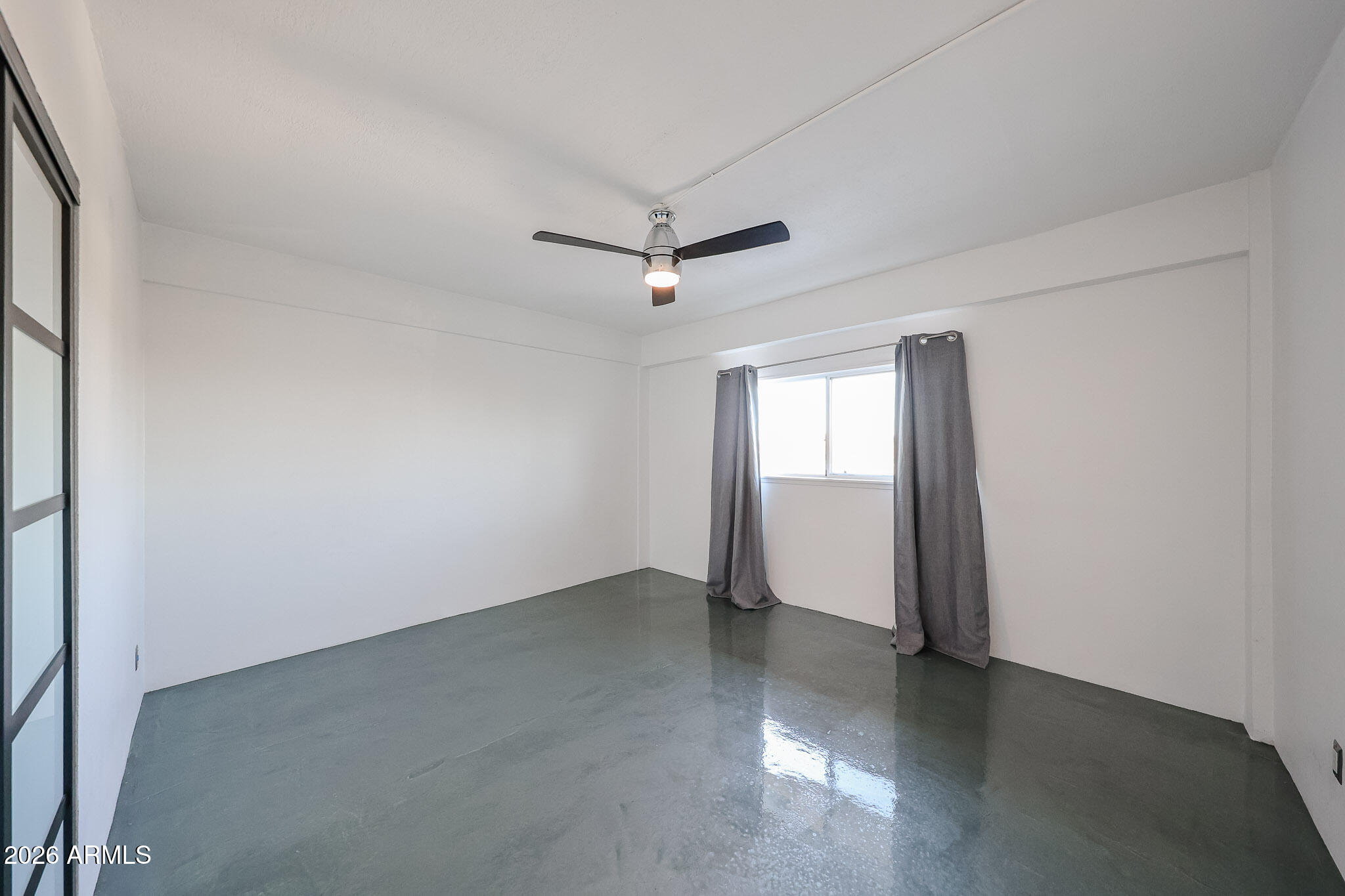 353 East Thomas Road, Unit C501 Phoenix, AZ 85004 - Photo 41 of 53 an empty room with a window and a ceiling fan