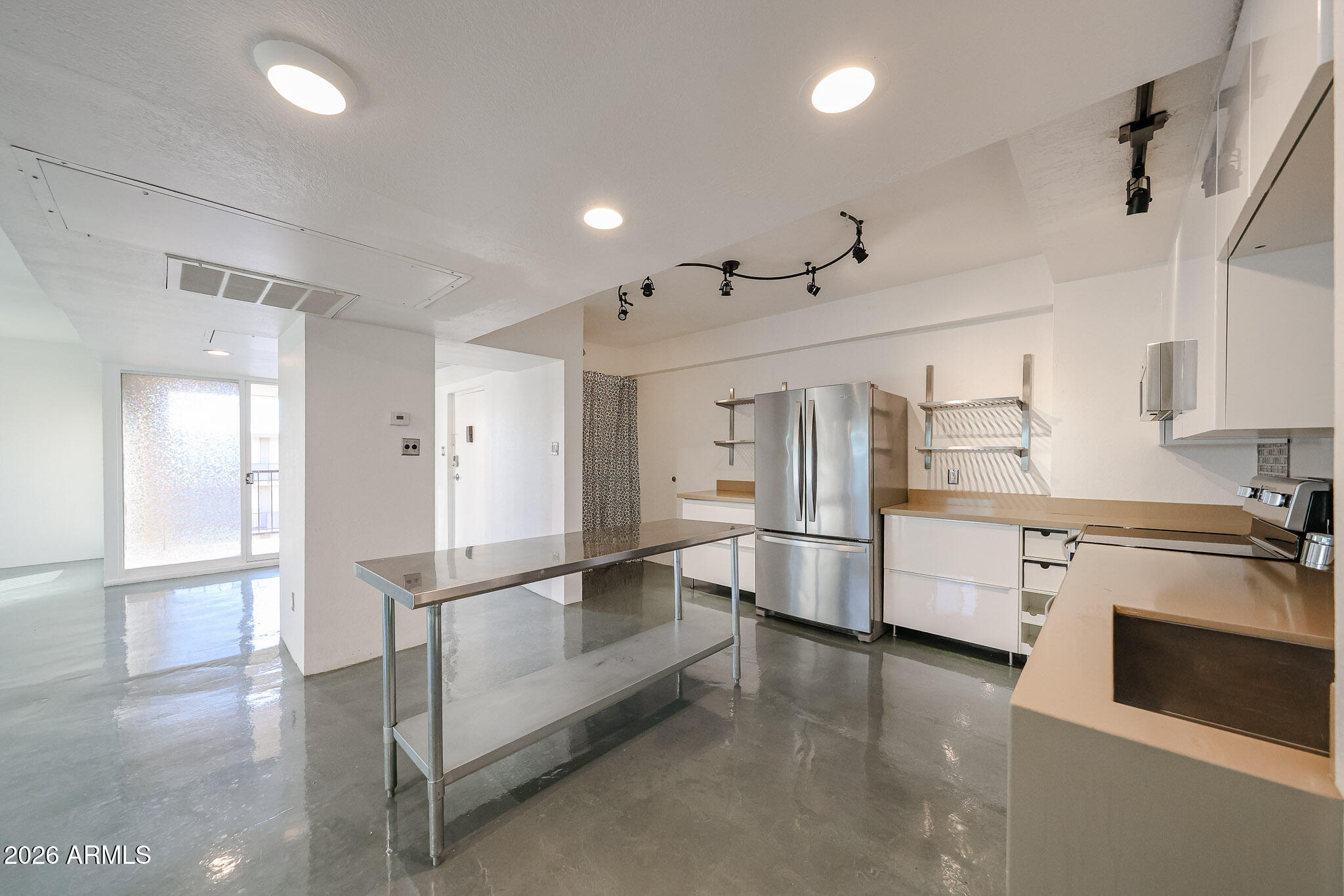 353 East Thomas Road, Unit C501 Phoenix, AZ 85004 - Photo 5 of 53 a large white kitchen with stainless steel appliances a stove a refrigerator a fireplace and white cabinets with wooden floor