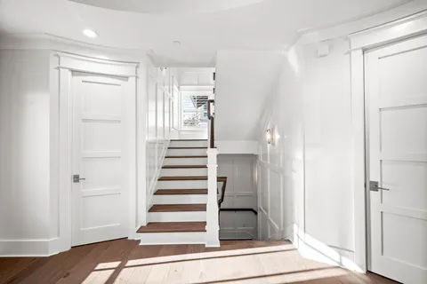 a large kitchen with dining table and wooden floor