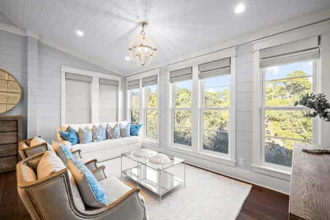 a living room with furniture chandelier and a mirror