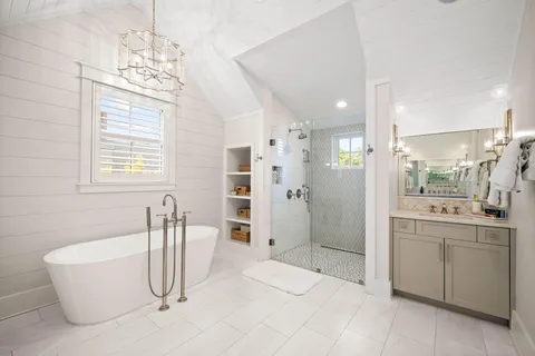 a spacious bathroom with a tub sink and mirror