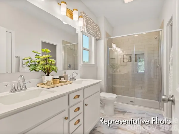 a bathroom with a granite countertop sink a mirror a bathtub and shower