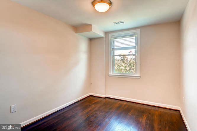 3821 Kimble Road Baltimore, MD 21218 - Photo 17 of 29 an empty room with wooden floor and windows