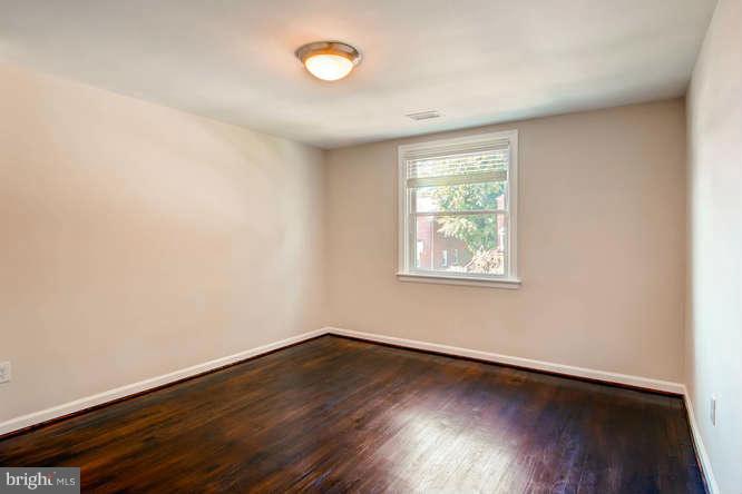 3821 Kimble Road Baltimore, MD 21218 - Photo 19 of 29 an empty room with wooden floor and windows