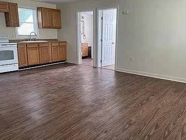 a large kitchen with wooden floors and white stainless steel appliances