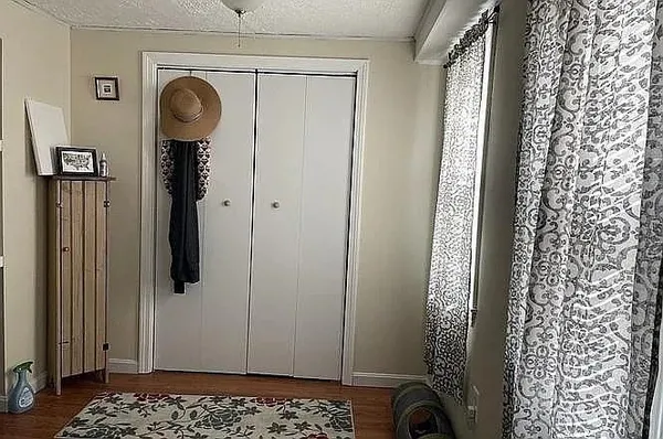 a view of a hallway with wooden floor and a door