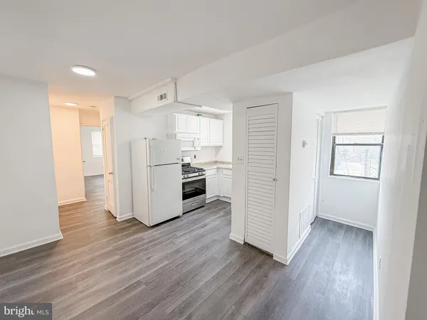 a kitchen with wooden floors and appliances