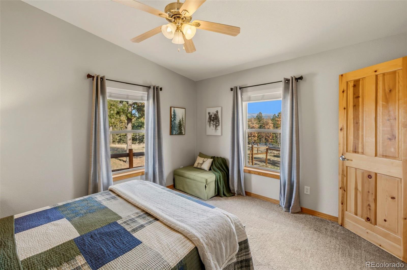 738 Rangeview Road Divide, CO 80814 - Photo 22 of 47 a bedroom with a bed and a chandelier