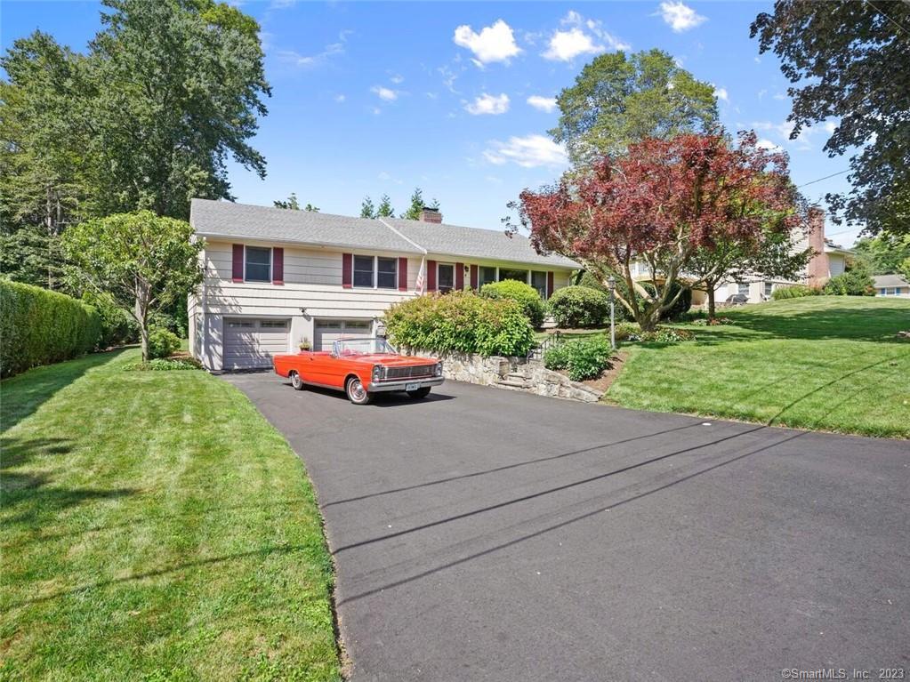 4 Redwood Road Norwalk, CT 06851 - Photo 1 of 1 a car parked in front of a brick house next to a yard