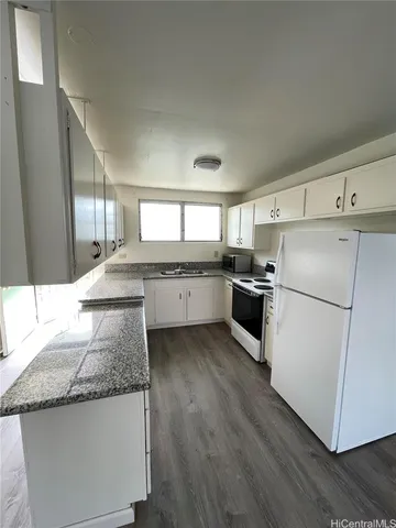 a kitchen with granite countertop stainless steel appliances and white cabinets