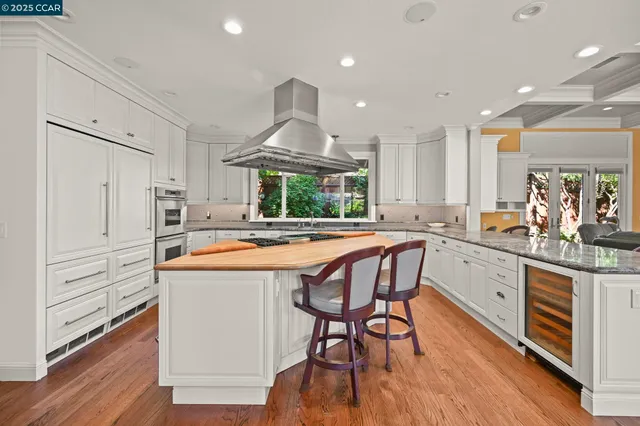 a view of a backyard with plants and a table and chairs under an umbrella