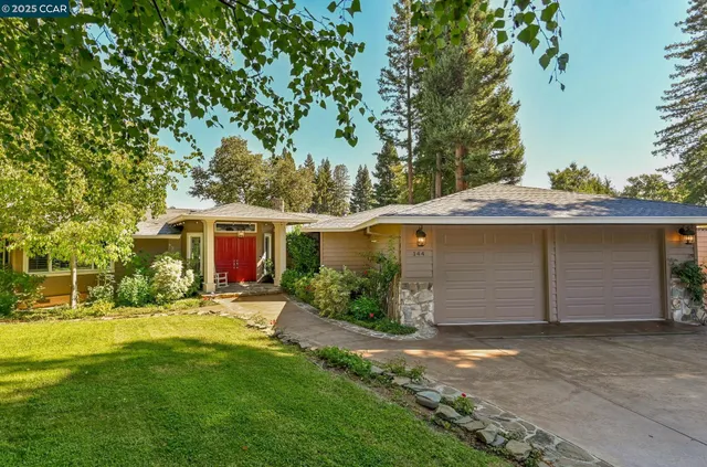 a view of an empty room with a fireplace and windows