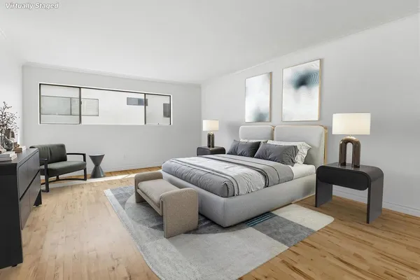 a bedroom with a bed wooden floor and lamp