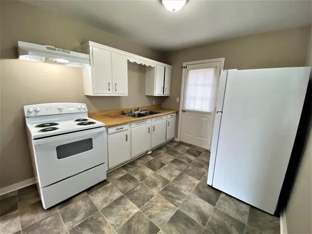 a kitchen with a stove a sink and a refrigerator