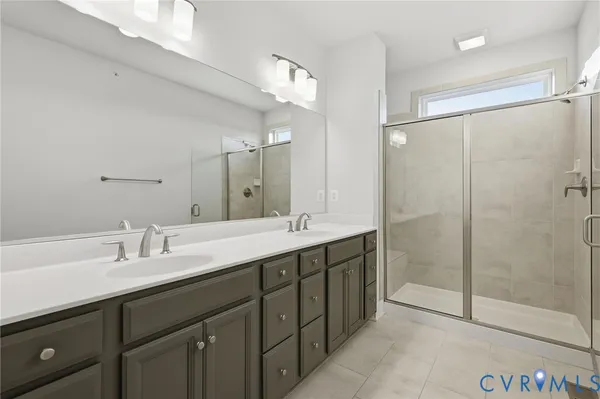 a bathroom with a double vanity sink mirror and shower