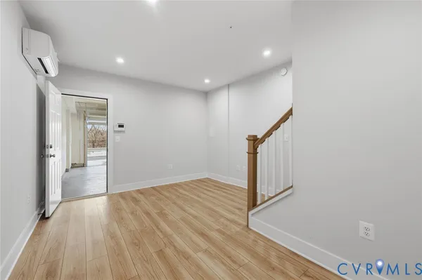 a view of a hallway with wooden floor and staircase